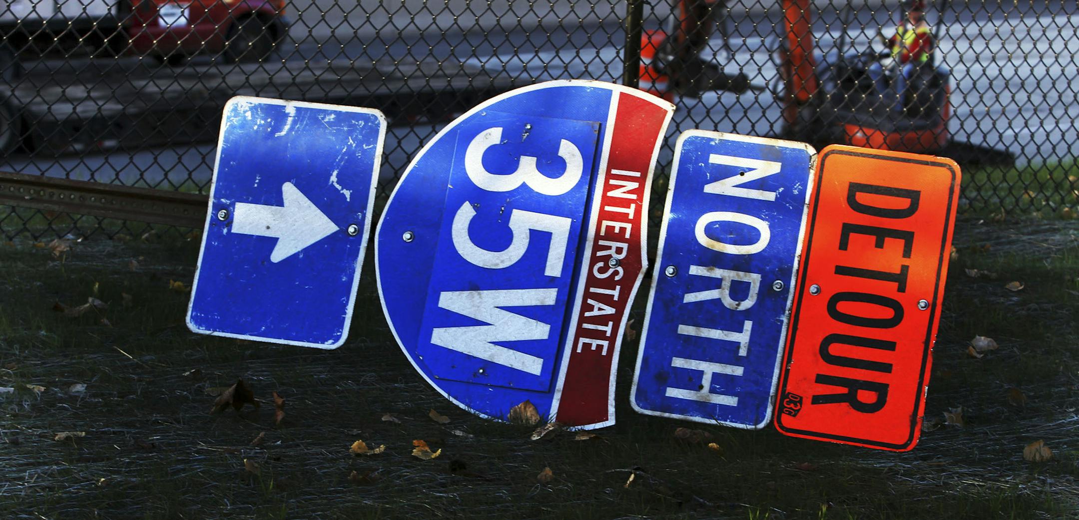 DAVID JOLES • djoles@startribune.com - Oct. 16, 2010 - Minneapolis, MN - ] Westbound Highway 62 closed over the weekend for work as the I-35W/62 Crosstown reconstruction nears its end. In this photo:] A detour sign sits by the roadway as a consturction worker operates machinery on the roadway of the 62 Crosstown westbound lane. ORG XMIT: MIN2013061116441156