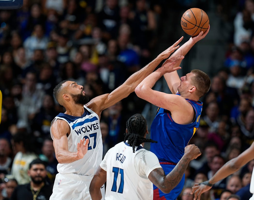 Minnesota Timberwolves center Rudy Gobert, left, goes up to block a shot by Denver Nuggets center Nikola Jokic, right, as Timberwolves center Naz Reid (11) looks on in the second half of Game 1 of an NBA basketball second-round playoff series Saturday, May 4, 2024, in Denver.