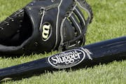 A Wilson baseball glove and a Louisville slugger bat sit on the field prior to a spring training baseball game between the Kansas City Royals and the 