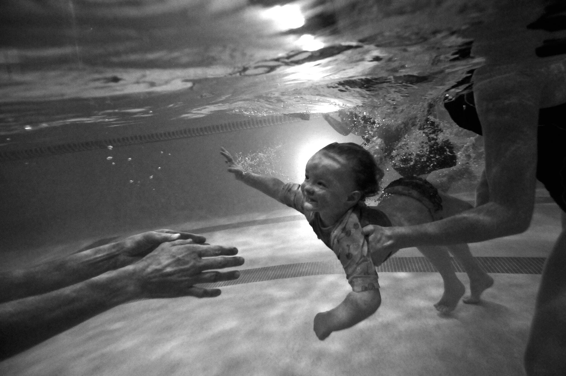 Brianna Gunderson passes her two year old daughter Ava to swimming instructor Katherine Schrock at the Family Swim School in Lakeville, during an open swim for infants. The water is constant 90 degrees at the Family Swim School in Lakeville,where Brianna Gunderson of Lakeville swims with her children 7 month old Liam and 2 year old Ava. Brianna Gunderson say's that swimming is "an essential life time skill that will help them with their motor skills and every day use,living in the land of ten th