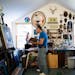 Denomie work surrounded by his own paintings and a vast collection of masks. ] MARK VANCLEAVE ¥ Minnesota artist Jim Denomie works in his Shafer, Min
