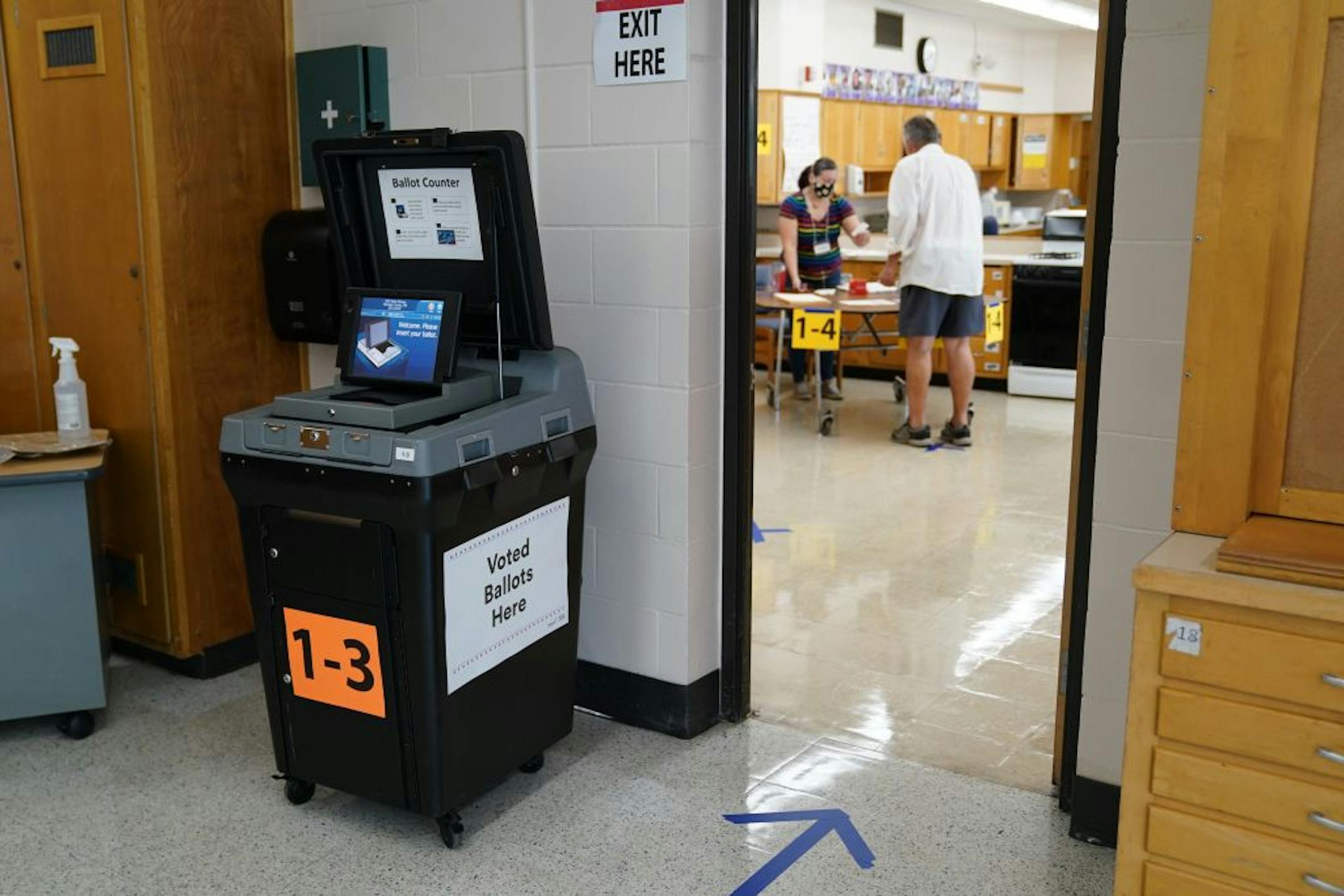 Voter Tom Dunnwald talked with election judge Jacqueline Quintanilla as he he arrived to cast his ballot Tuesday morning at Northeast Middle School in Minneapolis. Because of social distancing guidelines some precincts were combined into the same voting location.