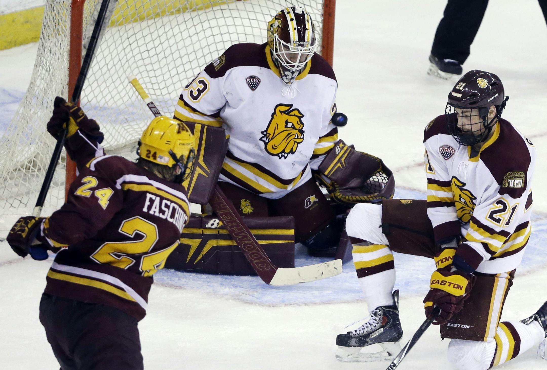 Minnesota Duluth goaltender Kasimir Kaskisuo (33) blocks a shot by Minnesota's Hudson Fasching (24) as Carson Soucy (21) helps to defend the net in the third period of an NCAA college hockey regional semifinal game in Manchester, N.H., Friday, March 27, 2015. Minnesota Duluth won 4-1. (AP Photo/Elise Amendola)