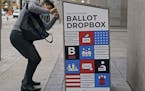 A voter makes sure his ballot falls into the ballot drop box outside the Boston Public Library, Monday, Oct. 26, 2020, in Boston. Massachusetts electi