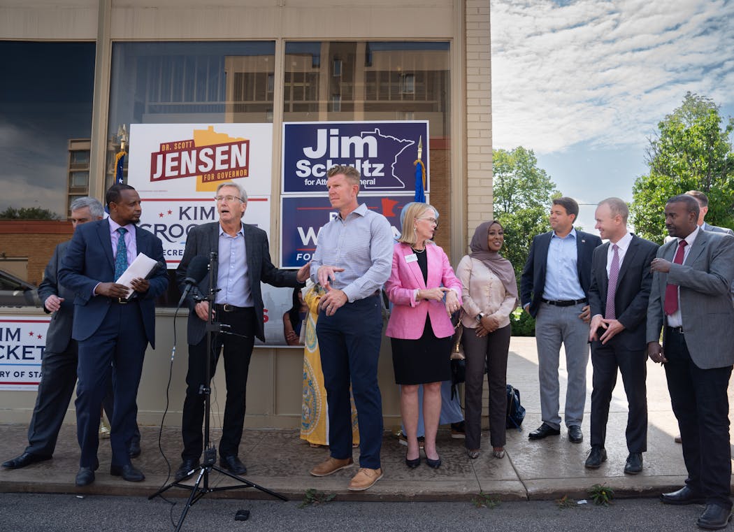 Surrounded by other Republican candidates and community leaders, Scott Jensen, center, and Matt Birk, right, spoke at the opening of the Minnesota GOP Somali community center.