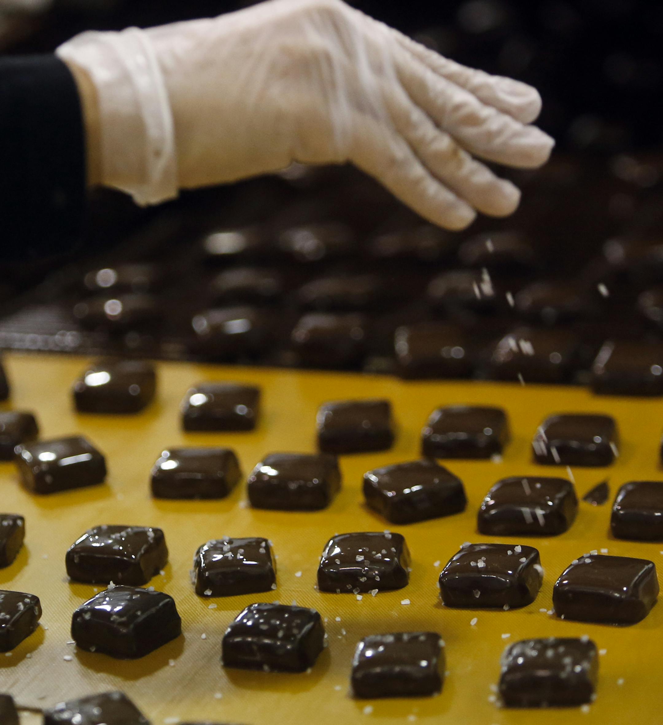 Candy maker Kim Heng sprinkles sea salt on top of dark chocolate covered cream caramelTuesday, Nov. 19 at Abdallah's Candies in Burnsville, MN.](DAVID JOLES/STARTRIBUNE) djoles@startribune.comThe production lines are humming at Abdallah's Candies, the 100-year-old maker of chocolates, caramels and toffees that's been a mainstay in Burnsville since the 1960s. Christmas accounts for about 35 percent of its business. The Burnsville facility has a small shop but most of its devoted to production --