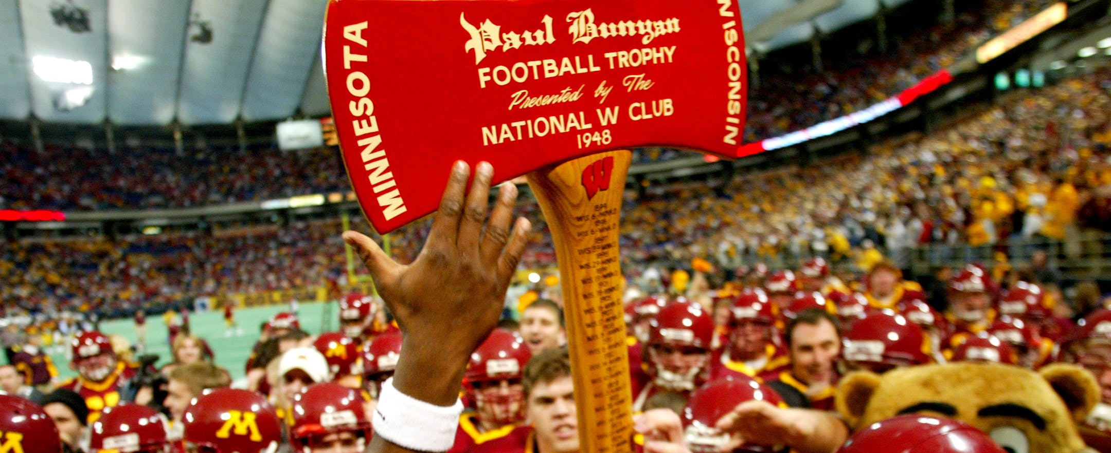 The Gopher football team lift up the Paul Bunyan axe that is headed back to the Minnesota trophy case after defeating Wisconsin 37-34 Saturday afternoon. 11/08/03 - Metrodome - Minneapolis
