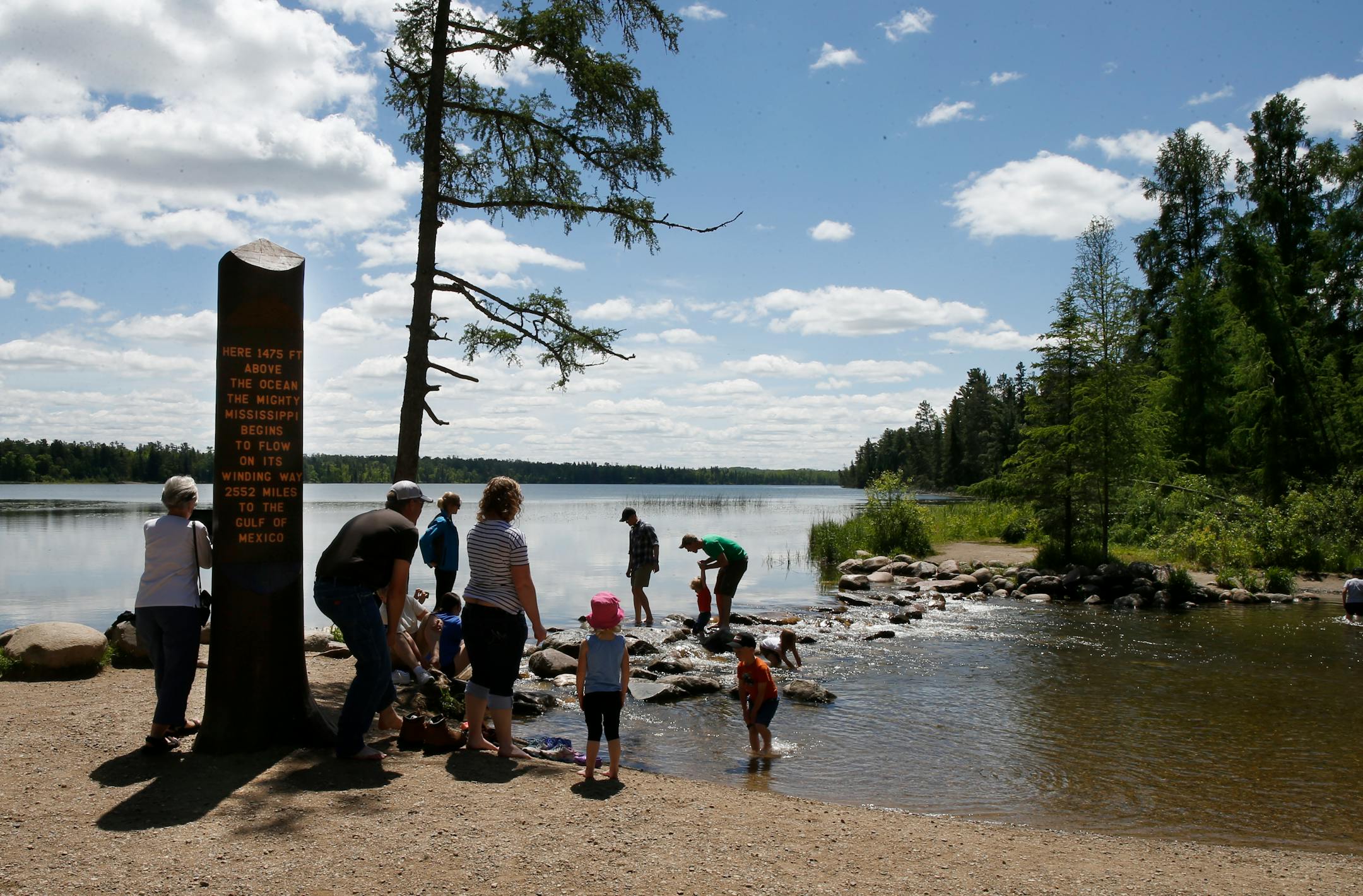 Visitors wade in the headwaters of the Mississippi River at Itasca State Park.