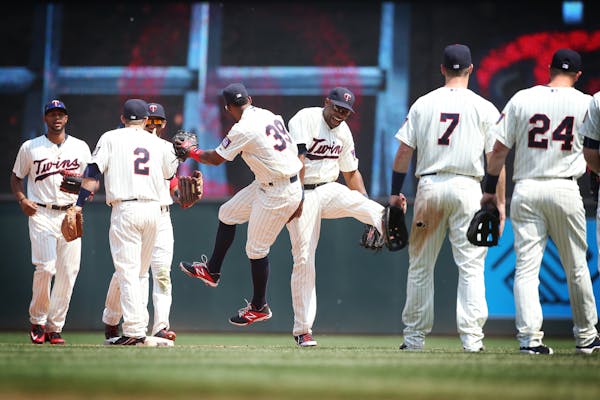 Minnesota Twins right fielder Torii Hunter (48), center, and other players celebrate their 6-4 win over the Boston Red Sox at Target Field in Minneapo