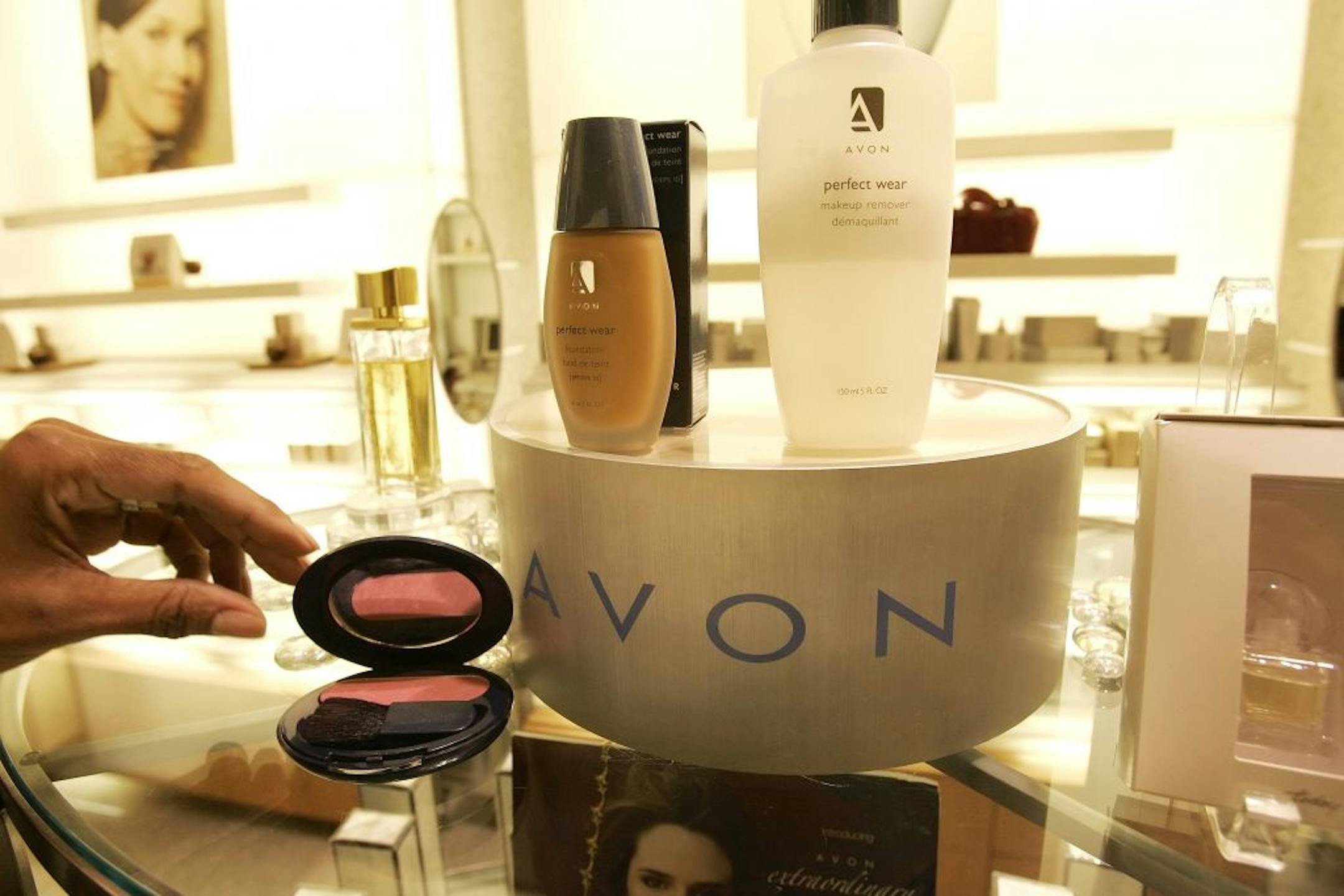 FILE - In this file photo made Nov. 15, 2005, a saleswoman, who did not give her name, places items for a picture on display in an Avon store in New York. Struggling Avon Products Inc. is rejecting a buyout offer worth about $10 billion from beauty company Coty Inc., as Coty went public with the bid Monday, April 2, 2012.