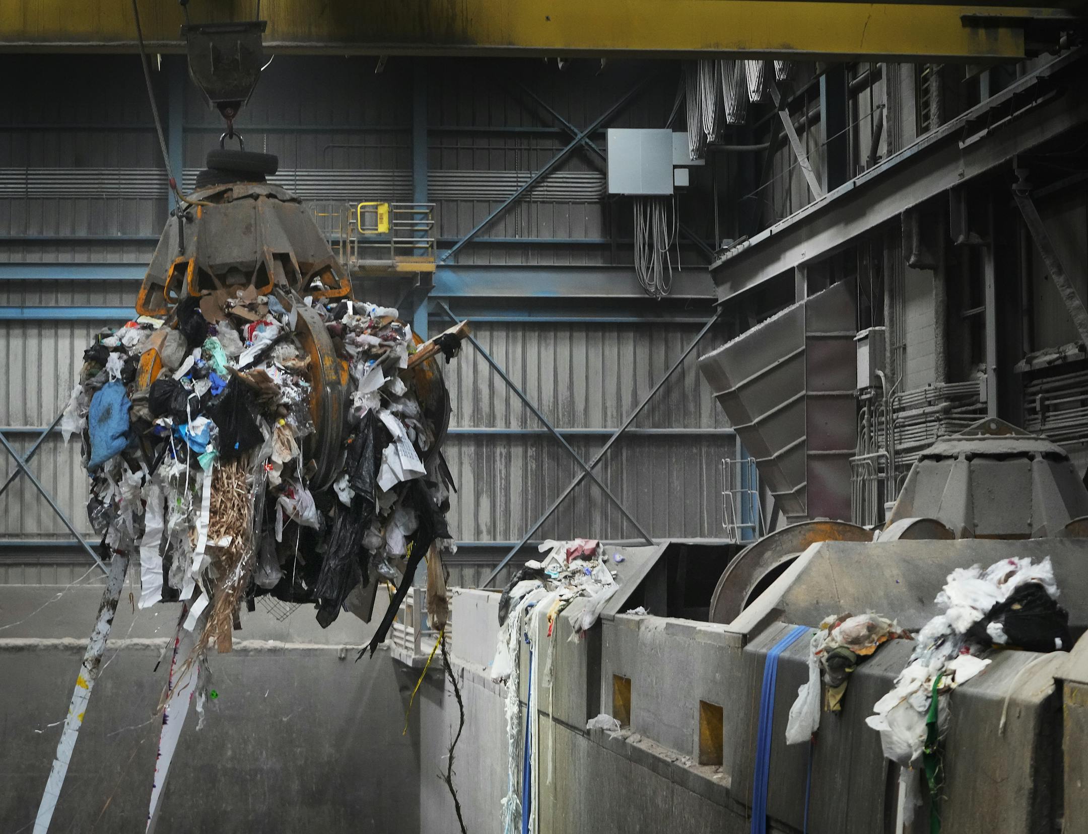 A claw from a crane lifts waste trucked in  into a boiler to be converted into energy at the Hennepin Energy Recovery Center.