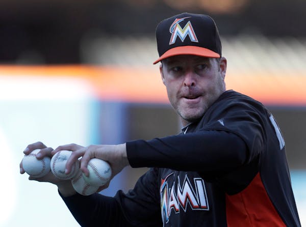 Miami Marlins manager Mike Redmond throws batting practice prior to a baseball game against the New York Mets at Citi Field, Friday, April 5, 2013 in 