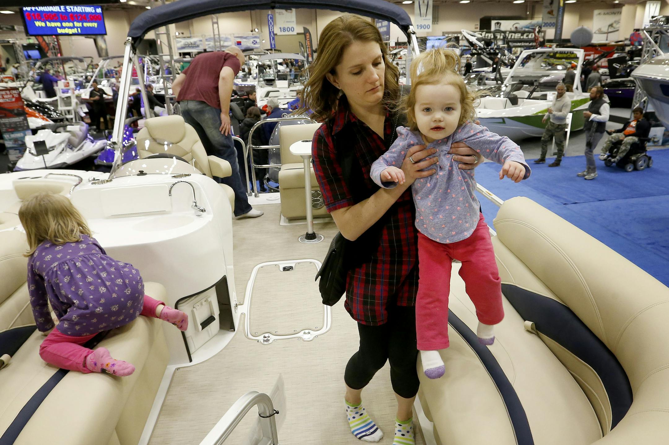 Jenna Pederson held daughter Rainey, 2 as the rest of her family Kani, 3 and husband Eric of White Bear Lake looked over a pontoon at the Minneapolis Boat Show at the Minneapolis Convention Center on Sunday. ] CARLOS GONZALEZ cgonzalez@startribune.com, January 25, 2015, Minneapolis, Minn., standalone photo from the Minneapolis Boat Show, Minneapolis Convention Center.
