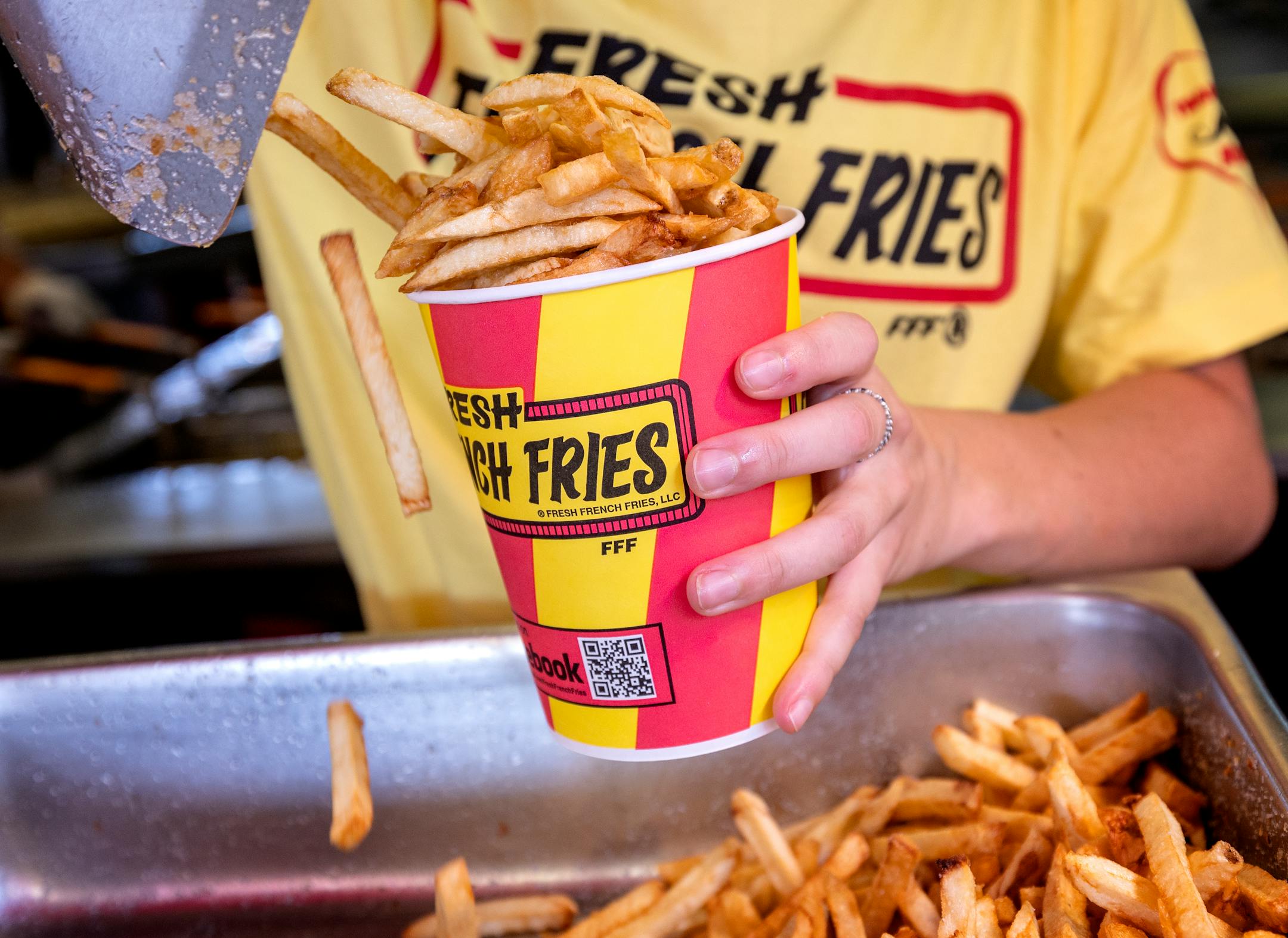 A French Fries stand employee loaded up a cup a fries Thursday, August 25, 2022, at The Minnesota State Fair in Falcon Heights, Minn.