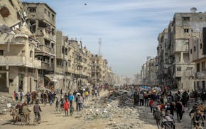 Palestinians gather in a street as humanitarian aid is airdropped in Gaza City on March 1, 2024, amid the ongoing conflict between Israel and the Hama