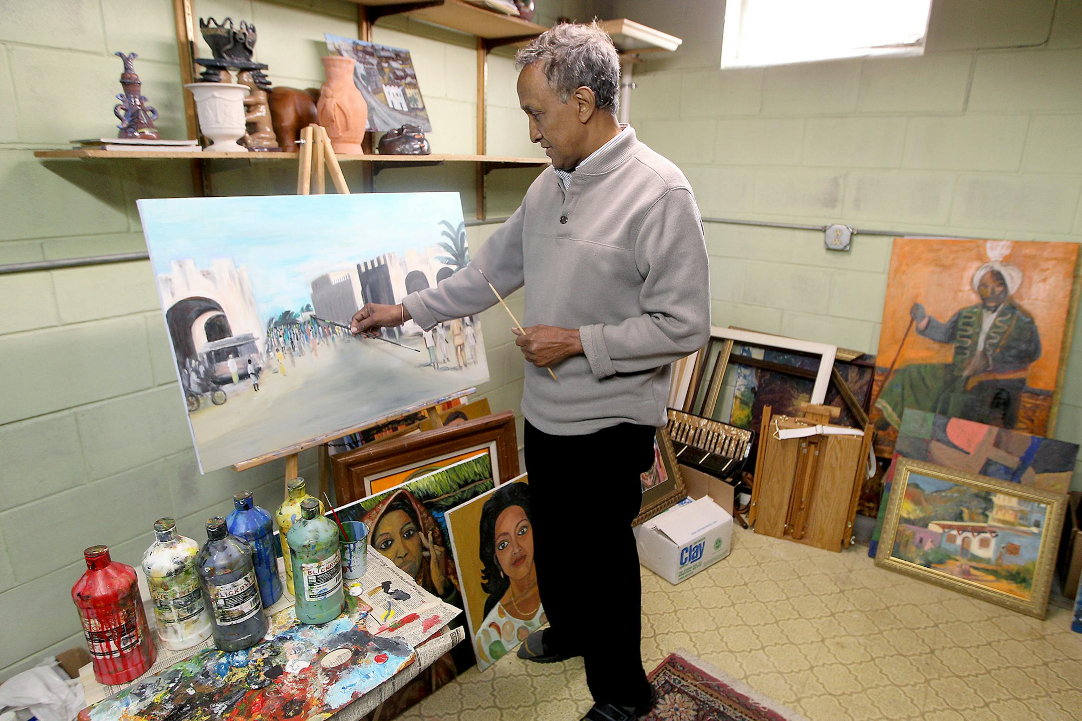 Abdulasis, also known as Aziz, worked on a piece from his home art studio, Friday, May 22, 2015. A lot of his art is hanging at his Columbia Heights home and has a mural at the Midtown Global Market in Minneapolis. ] (ELIZABETH FLORES/STAR TRIBUNE) ELIZABETH FLORES • eflores@startribune.com