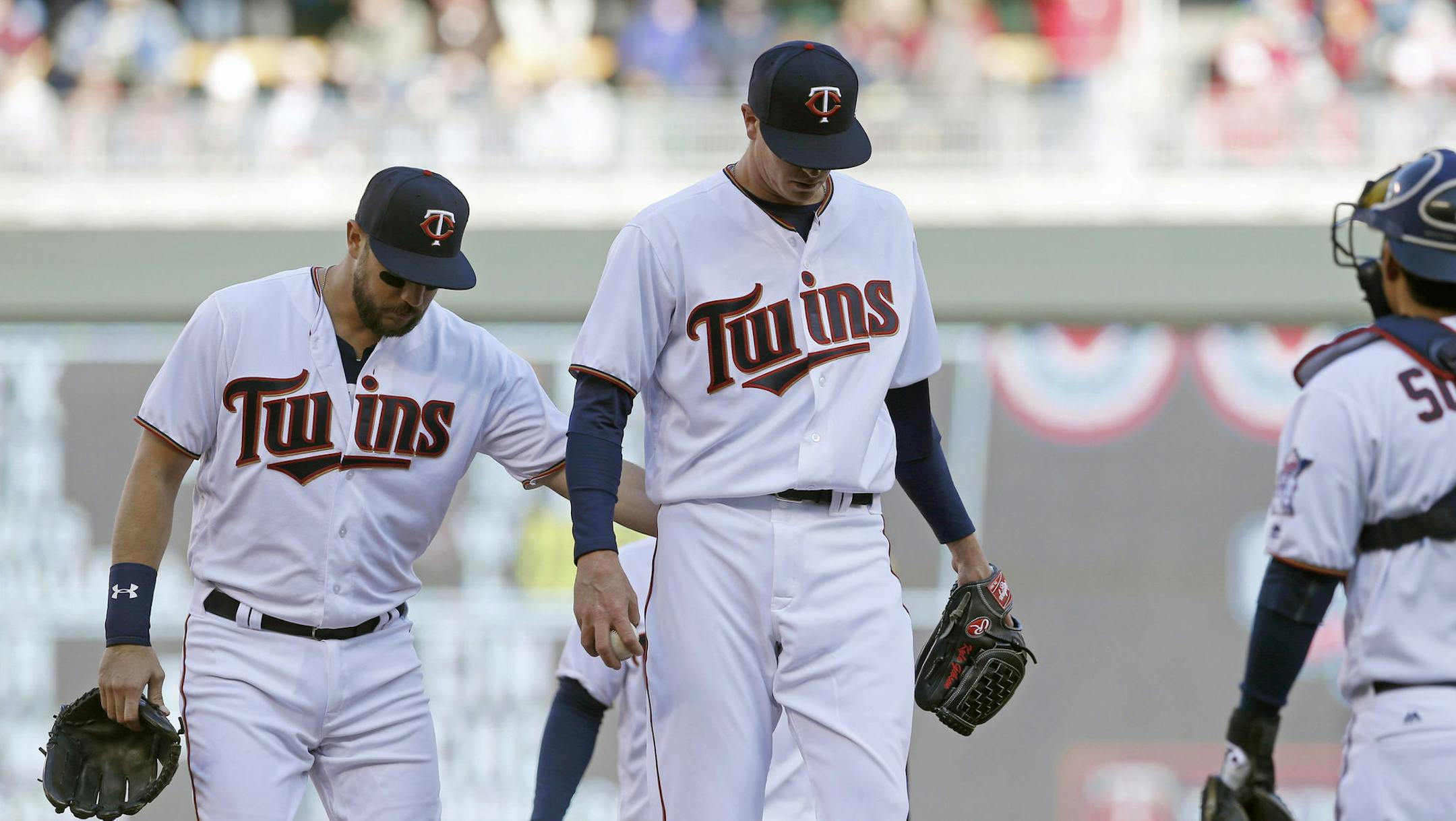 In this April 11, 2016 photo, Minnesota Twins pitcher Kyle Gibson gets a pat on the back from third baseman Trevor Plouffe as he is about to be pulled from the baseball game against the Chicago White Sox in Minneapolis. The Twins are the only winless team left in the American League, off to the franchise's worst start since they were the Washington Senators in 1904. They have the majors-most 79 strikeouts. (AP Photo/Jim Mone)