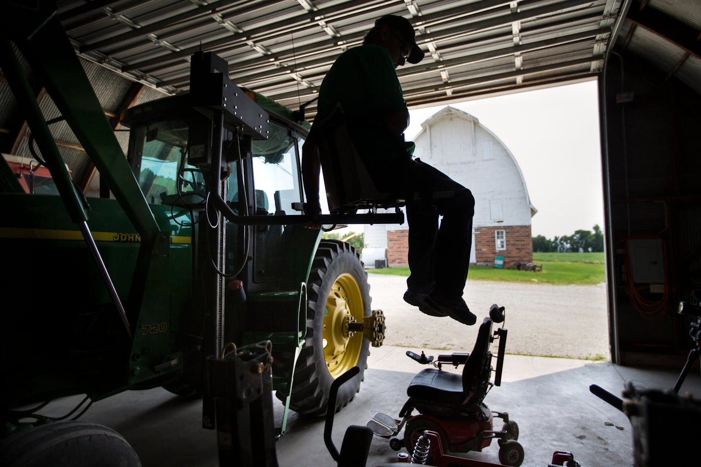 Scott Collier was paralyzed in a farm accident two years ago. He was able to get back to farming with help from the AgrAbility program by modifying and adding new farm equipment. He was photographed using a remote lift that moves him from his wheel chair to the cab of his tractor on Thursday, July 2, 2015, in Montgomery, Minn. ] RENEE JONES SCHNEIDER • reneejones@startribune.com