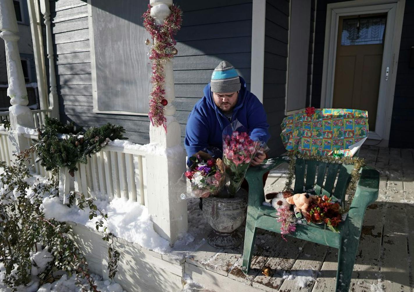 Neighbor Eric Stiver put flowers and stuffed animals on a chair on the porch of the home where David Schladetzky shot and killed Kjersten Schladetzky and her sons, William and Nelson on Sunday.