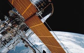 In this April 25, 1990 photograph provided by NASA, most of the giant Hubble Space Telescope can be seen as it is suspended in space by Discovery's Re