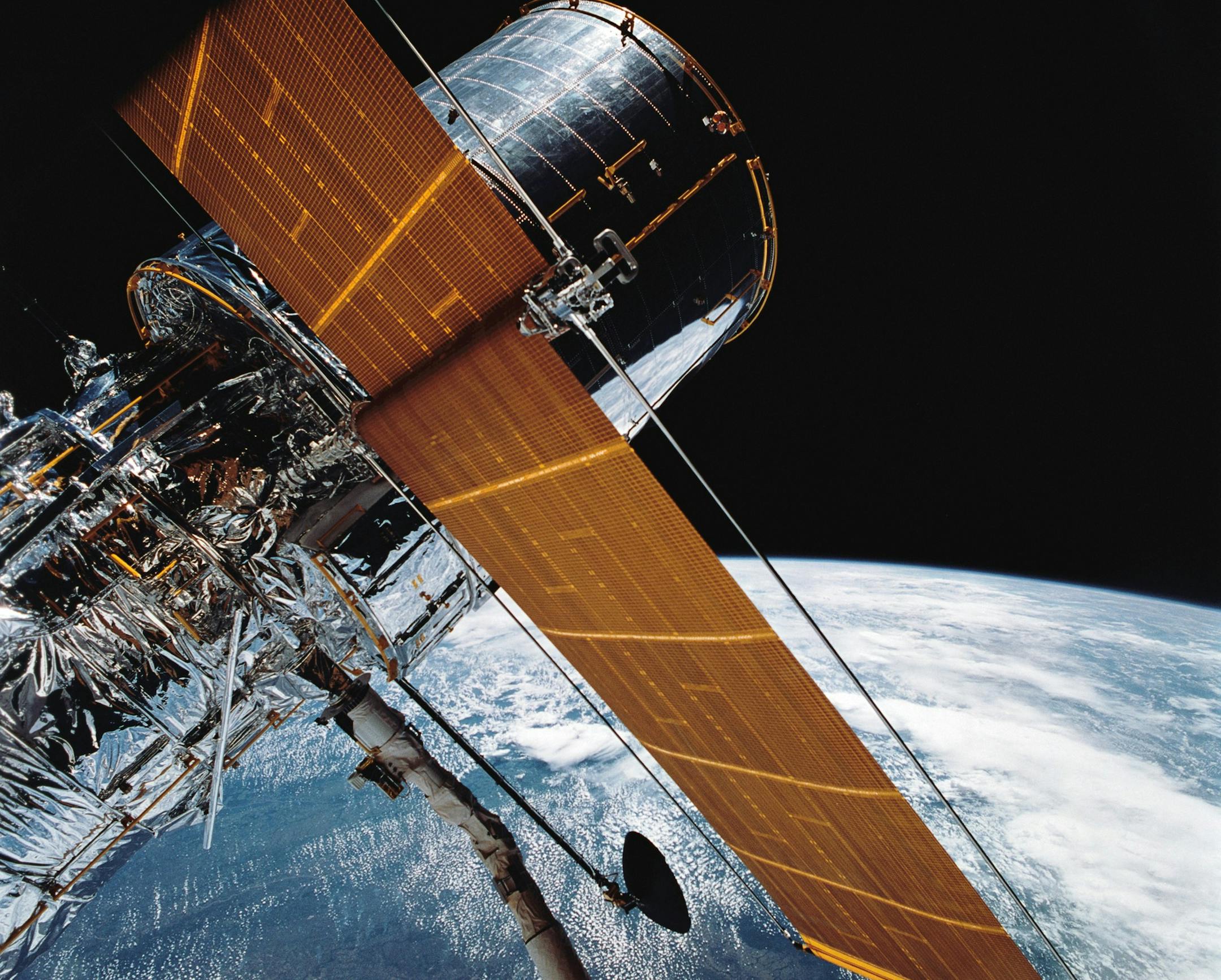 In this April 25, 1990 photograph provided by NASA, most of the giant Hubble Space Telescope can be seen as it is suspended in space by Discovery's Remote Manipulator System (RMS) following the deployment of part of its solar panels and antennae. This was among the first photos NASA released on April 30 from the five-day STS-31 mission. The Hubble Space Telescope, one of NASA'S crowning glories, marks its 25th anniversary on Friday, April 24, 2015. With more than 1 million observations, includin