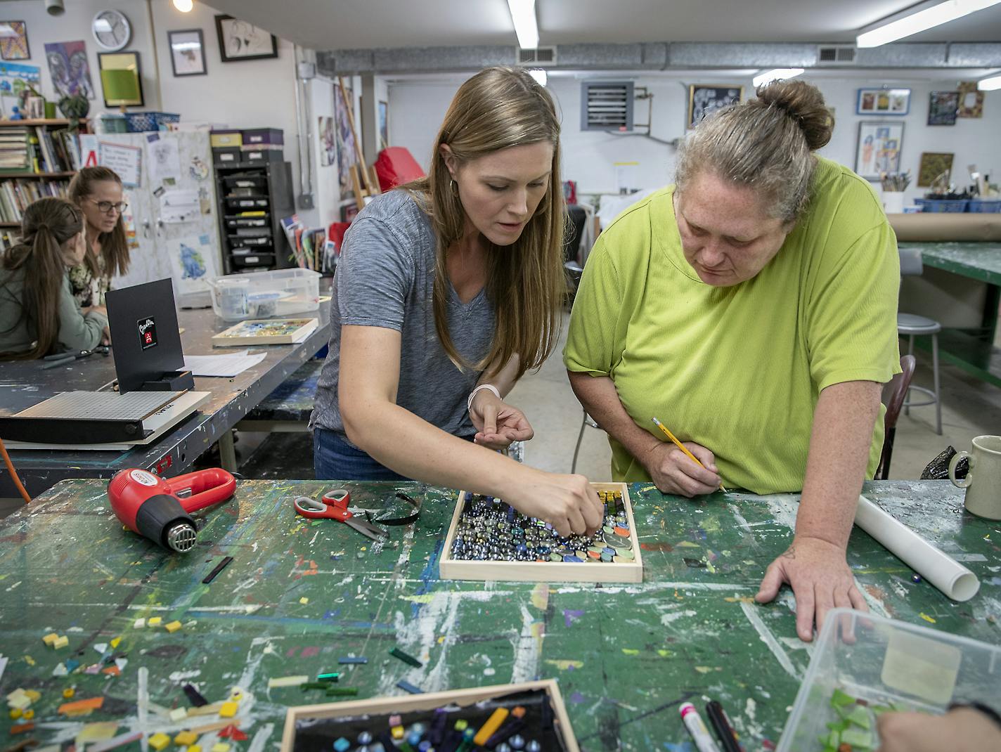 Sharra Frank, cq, left, a Compas teaching artist, worked with Tammi Reeves during a mosaic making art class at Avivo, Wednesday, September 25, 2019 in Minneapolis, MN. Avivo, a nonprofit, is expanding an arts program for adults living with mental illness. The nonprofit has used the arts for the past decade, finding that it helps increase people's confidence and sense of community. Avivo is expanding to bring in teaching artists to do classes for those with mental illness. ] ELIZABETH FLORES &#x2