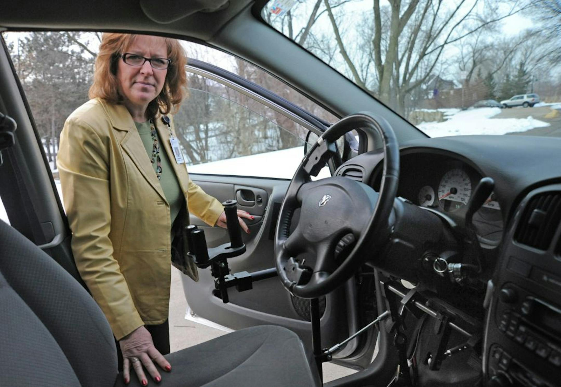 Connie Shaffer is a driver instructor at Courage Center who oversees the learning-disabled program . In this portrait she is with a dual control mini - van that's used for driver training. .