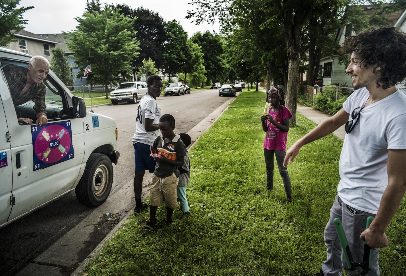 Trucker and triplex owner Moises Romo got some help from the children of his Kenyan tenants while doing yard work. He reward them with some frozen treats from ice cream vendor Dan Assar.