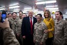 President Donald Trump and first lady Melania Trump take a photo with military personnel in a dining hall at the al-Asad Air Base in Iraq's Anbar prov