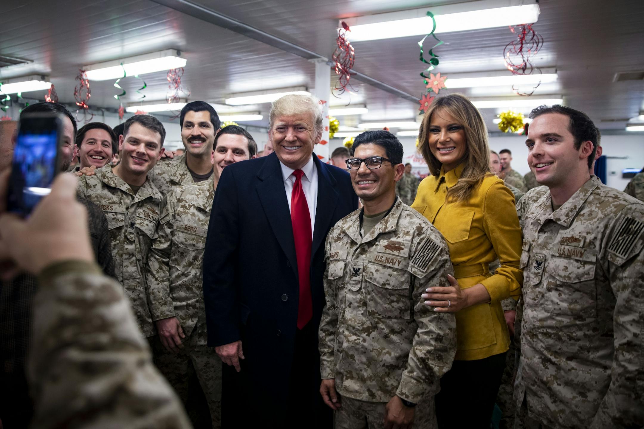 President Donald Trump and first lady Melania Trump take a photo with military personnel in a dining hall at the al-Asad Air Base in Iraq's Anbar province, Dec. 26, 2018. The surprise trip, which came in the midst of a government shutdown, was Trump's first visit to troops stationed abroad in a combat zone.