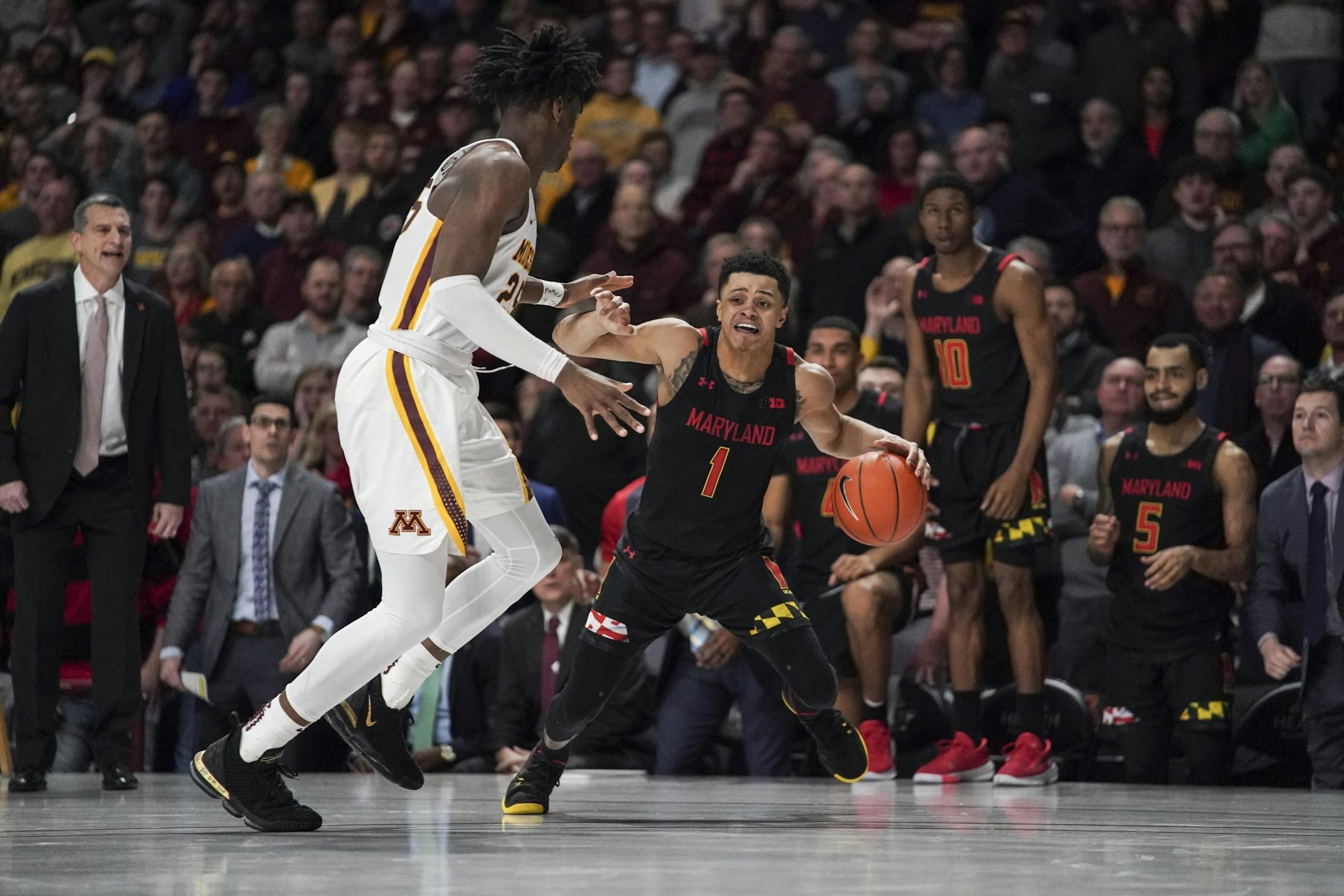 Maryland Terrapins guard Anthony Cowan Jr. (1) scrambled to find a way around Minnesota Gophers center Daniel Oturu (25) as Maryland trailed by a few point in the second half.