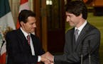 Canadian Prime Minister Justin Trudeau, right, and Mexican President Enrique Pena Nieto clasp hands at a joint news conference on Parliament Hill in O