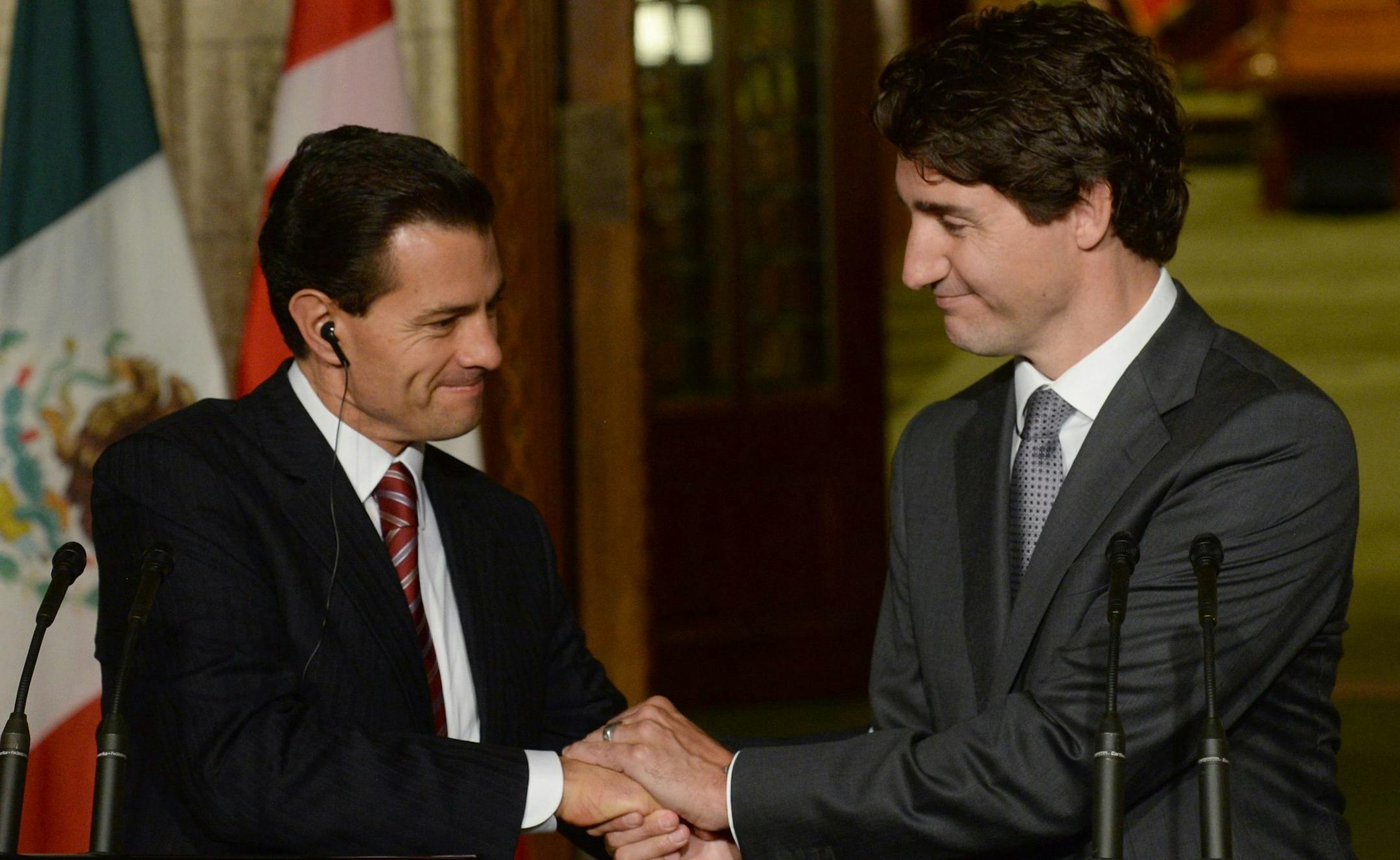 Canadian Prime Minister Justin Trudeau, right, and Mexican President Enrique Pena Nieto clasp hands at a joint news conference on Parliament Hill in Ottawa, Ontario, on Tuesday, June 28, 2016. (Adrian Wyld /The Canadian Press via AP) MANDATORY CREDIT