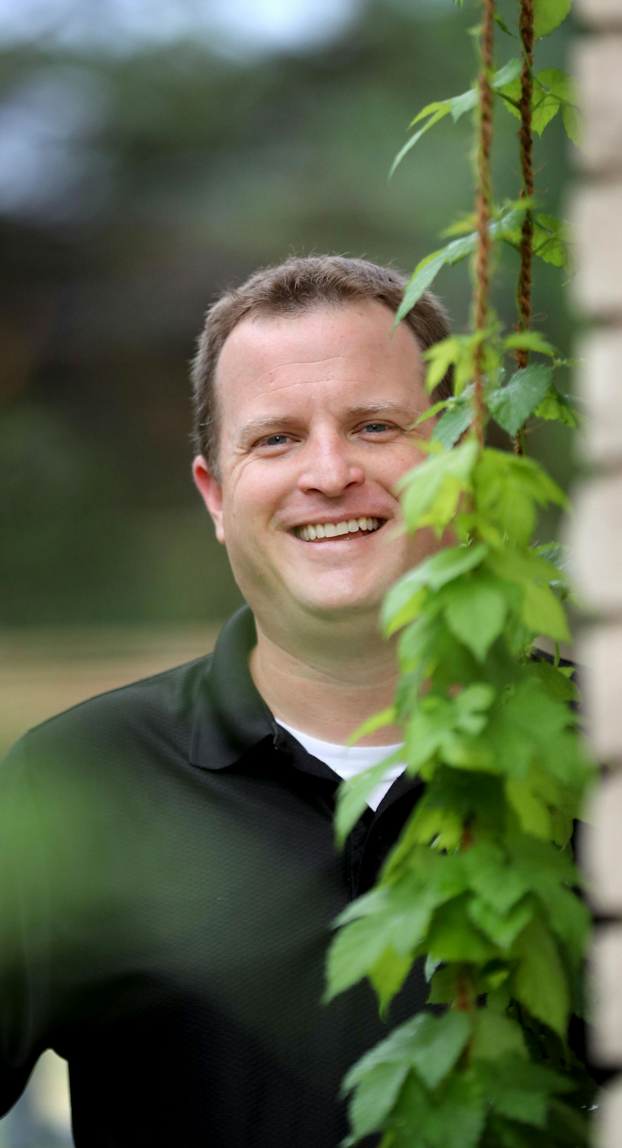 Freelance hops grower Matt Weide with his hops plant outside his home.