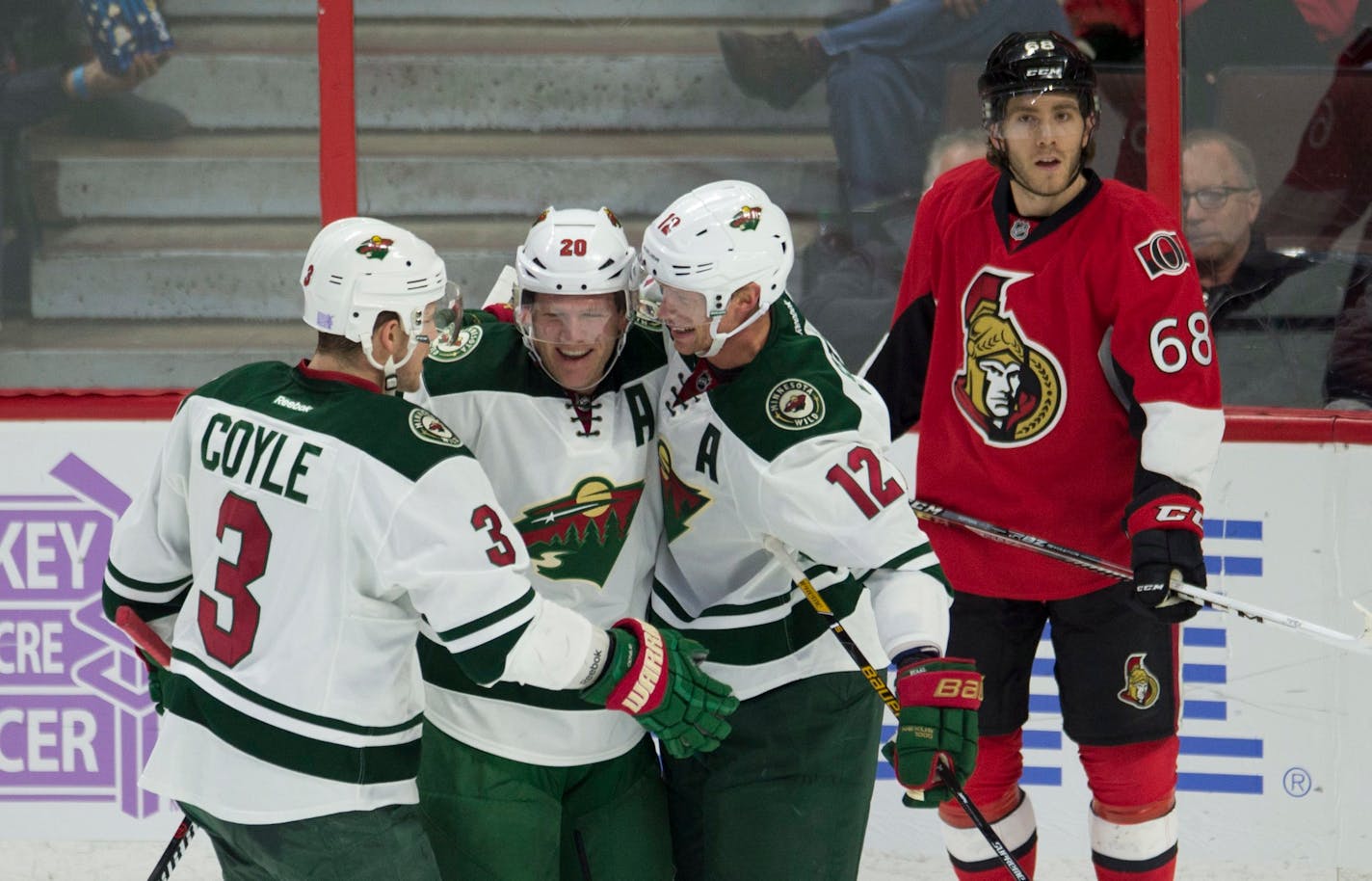 Ottawa Senators left wing Mike Hoffman (68) waits as Minnesota Wild defenseman Ryan Suter (20) celebrates his goal with Eric Staal (12) and Charlie Coyle (3) during the first period of an NHL hockey game Sunday, Nov. 13, 2016, in Ottawa, Ontario. (Adrian Wyld/The Canadian Press via AP)