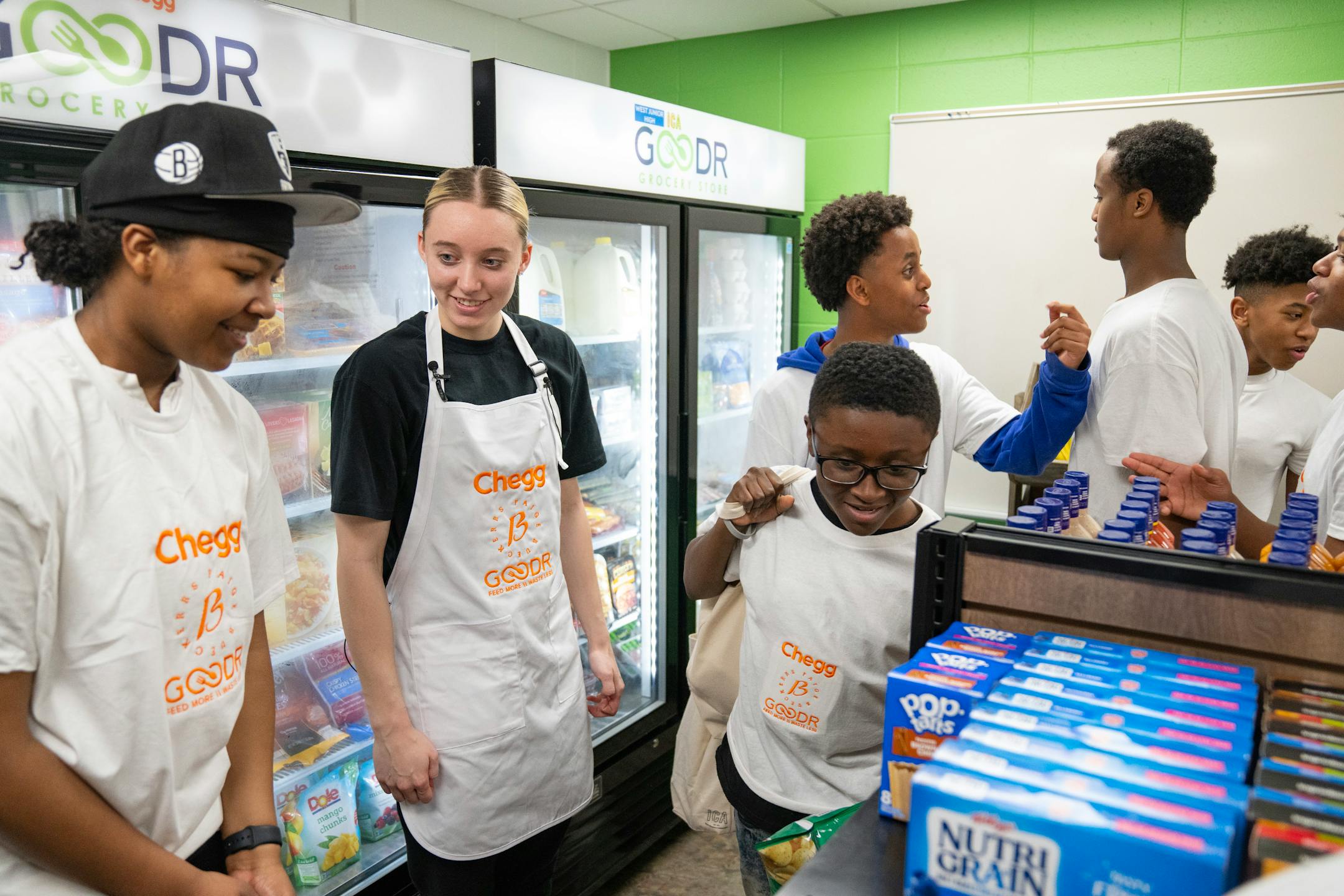Paige Bueckers walks and talks with students during the grand opening of a new free grocery store.