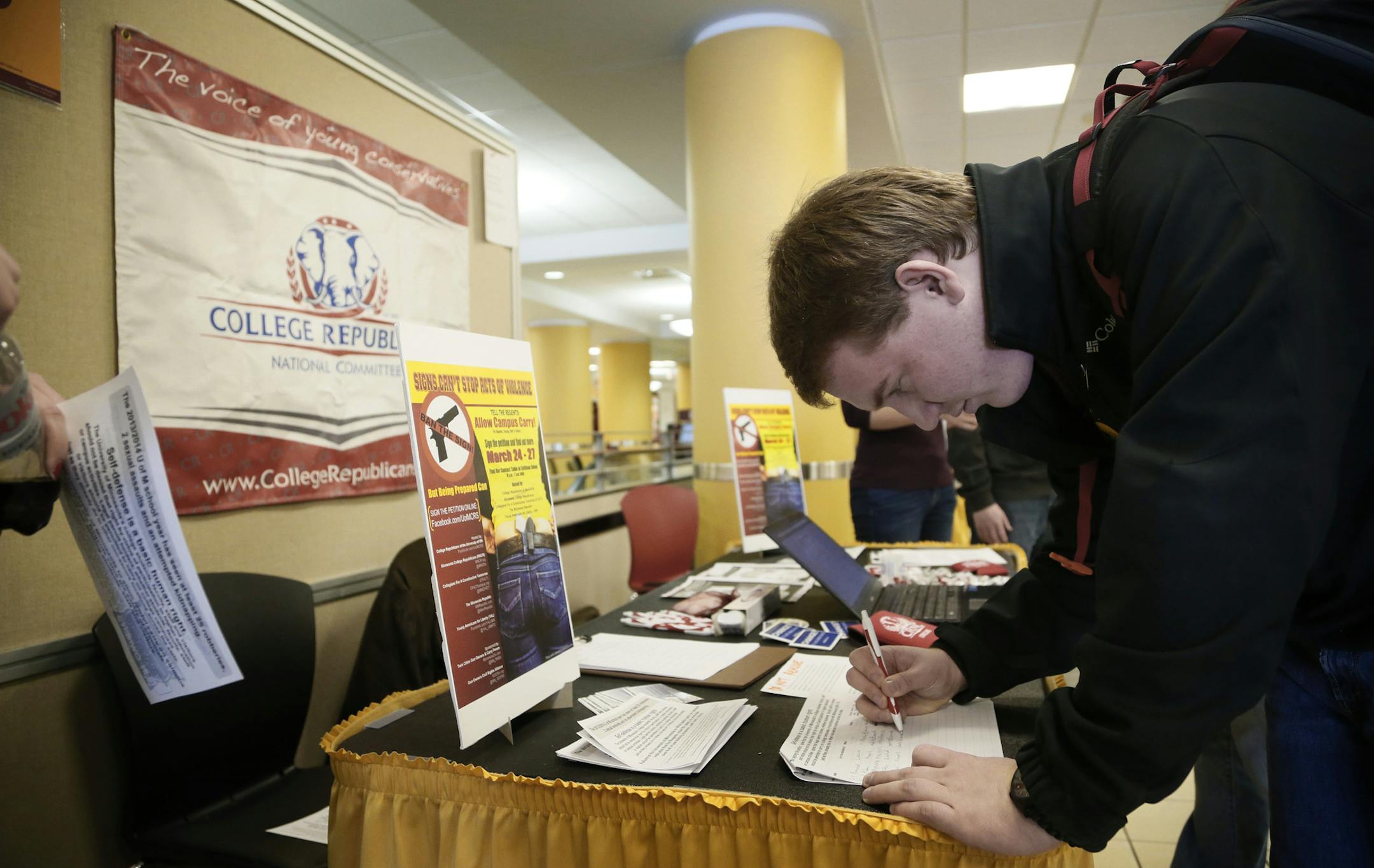 Nick Plaza a freshman from Lake Havasu , Arizona singed a petition that would allow staff and students to carry firearm Monday March 24, 2014 at The University of Minnesota in Minneapolis, MN. Minnesotans for right to keep and bear arms setup a booth at Coffman Union .]JERRY HOLT jerry.holt@startribune.com