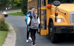 Students walk to board a school bus nicknamed "the secret bus," since these kids are basically doing reversed bussing, where they are leaving their sc