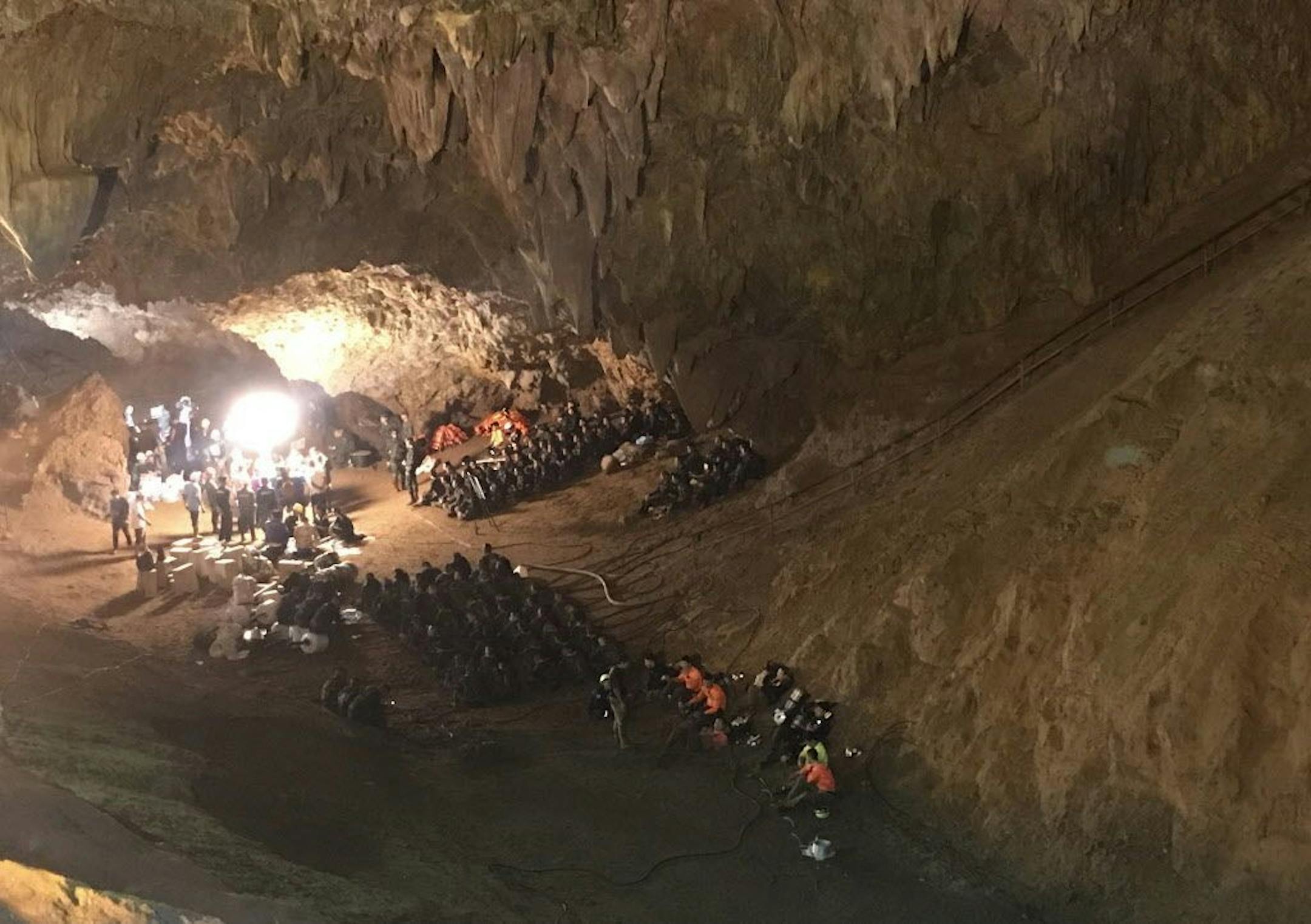 Emergency rescue teams gather in the staging area as they continue the search for a young soccer team and their coach believed to be missing in a large cave, Tuesday, June 26, 2018, in Mae Sai, Chiang Rai province, in northern Thailand. Intensive efforts to rescue 12 boys and their soccer coach who have been trapped inside a flooded cave for three days hinge on pumping out water so that navy divers have headroom to operate, the first high-level Thai official to visit the site in northern Thailan