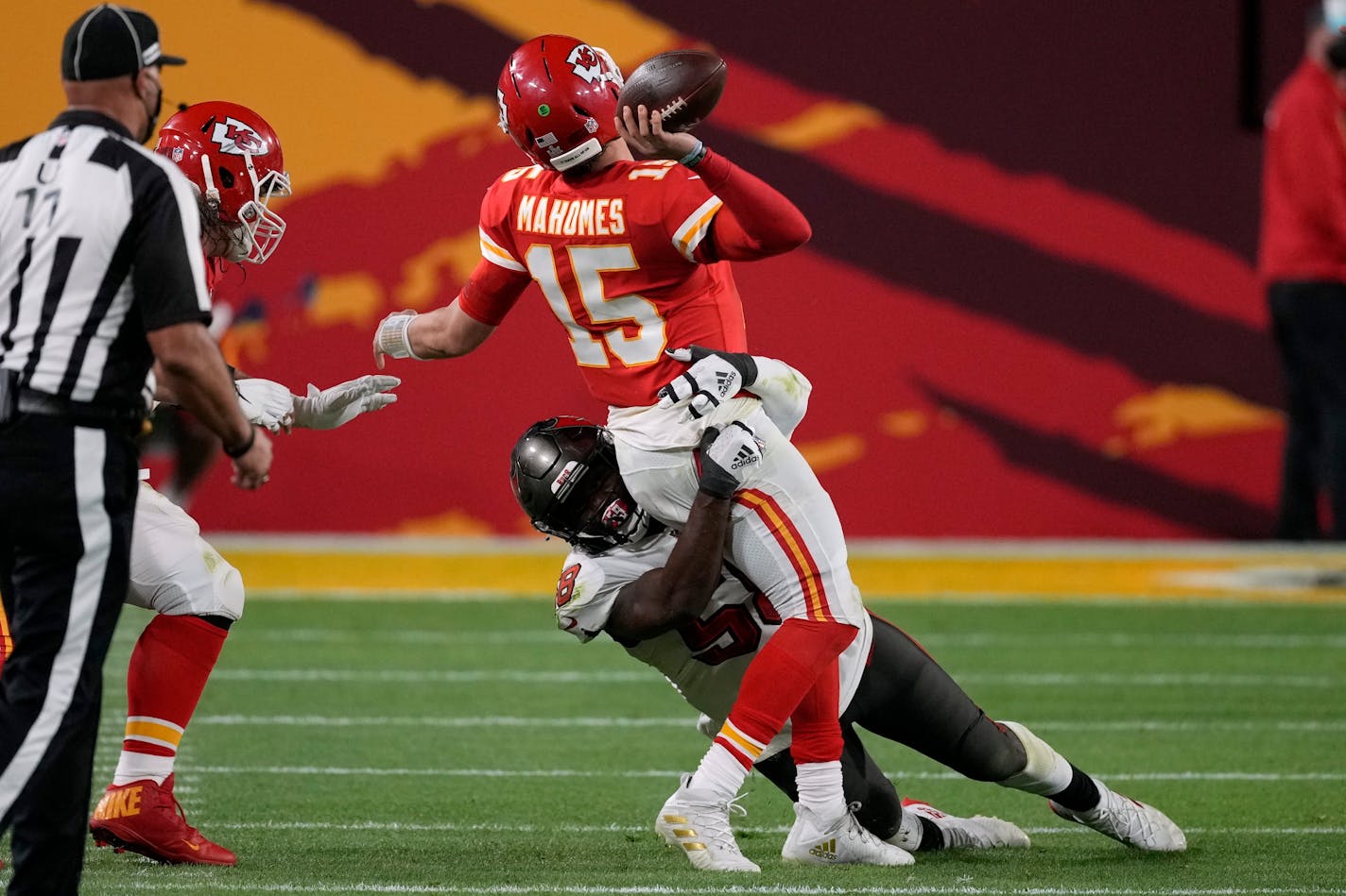 Kansas City Chiefs quarterback Patrick Mahomes (15) throws a pass while in the grasp of Tampa Bay Buccaneers outside linebacker Shaquil Barrett during the second half of the NFL Super Bowl 55 football game, Sunday, Feb. 7, 2021, in Tampa, Fla. (AP Photo/Chris O'Meara)