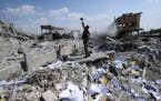 A Syrian soldier films the damage of the Syrian Scientific Research Center which was attacked by U.S., British and French military strikes to punish P