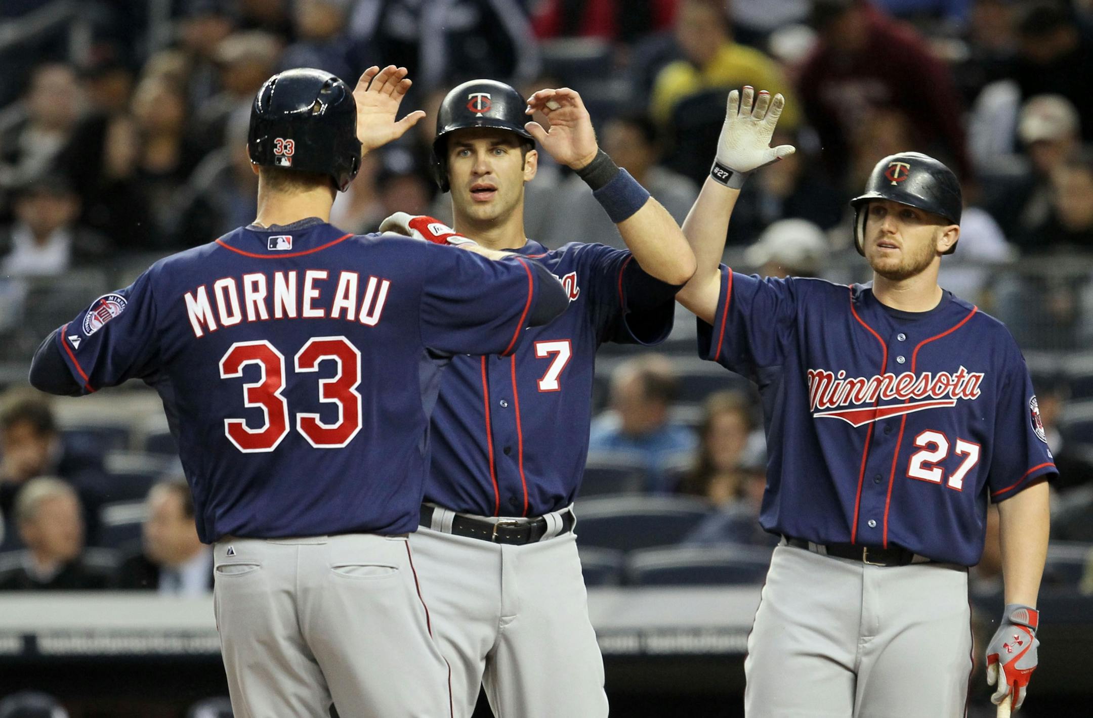 Justin Morneau celebrated his first-inning, two-run home run against the Yankees with teammates Joe Mauer (7) and Chris Parmelee. Morneau added a solo homer in the fifth inning.
