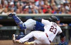 Minnesota Twins designated hitter Nelson Cruz (23) was safe at home in the first inning after Kansas City Royals catcher Nick Dini (33) failed to make