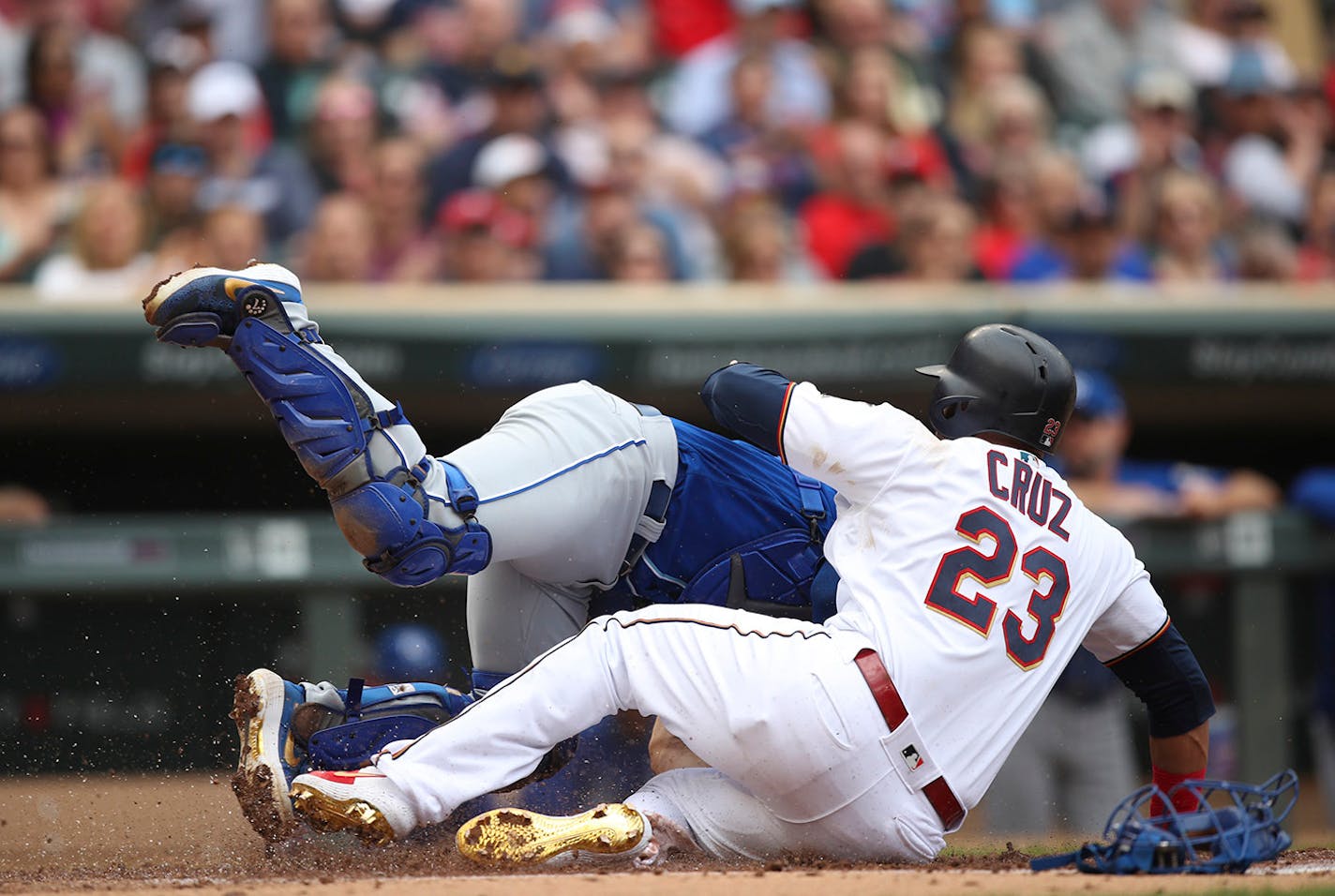 Minnesota Twins designated hitter Nelson Cruz (23) was safe at home in the first inning after Kansas City Royals catcher Nick Dini (33) failed to make a tag. He scored on a single by Marwin Gonzalez.