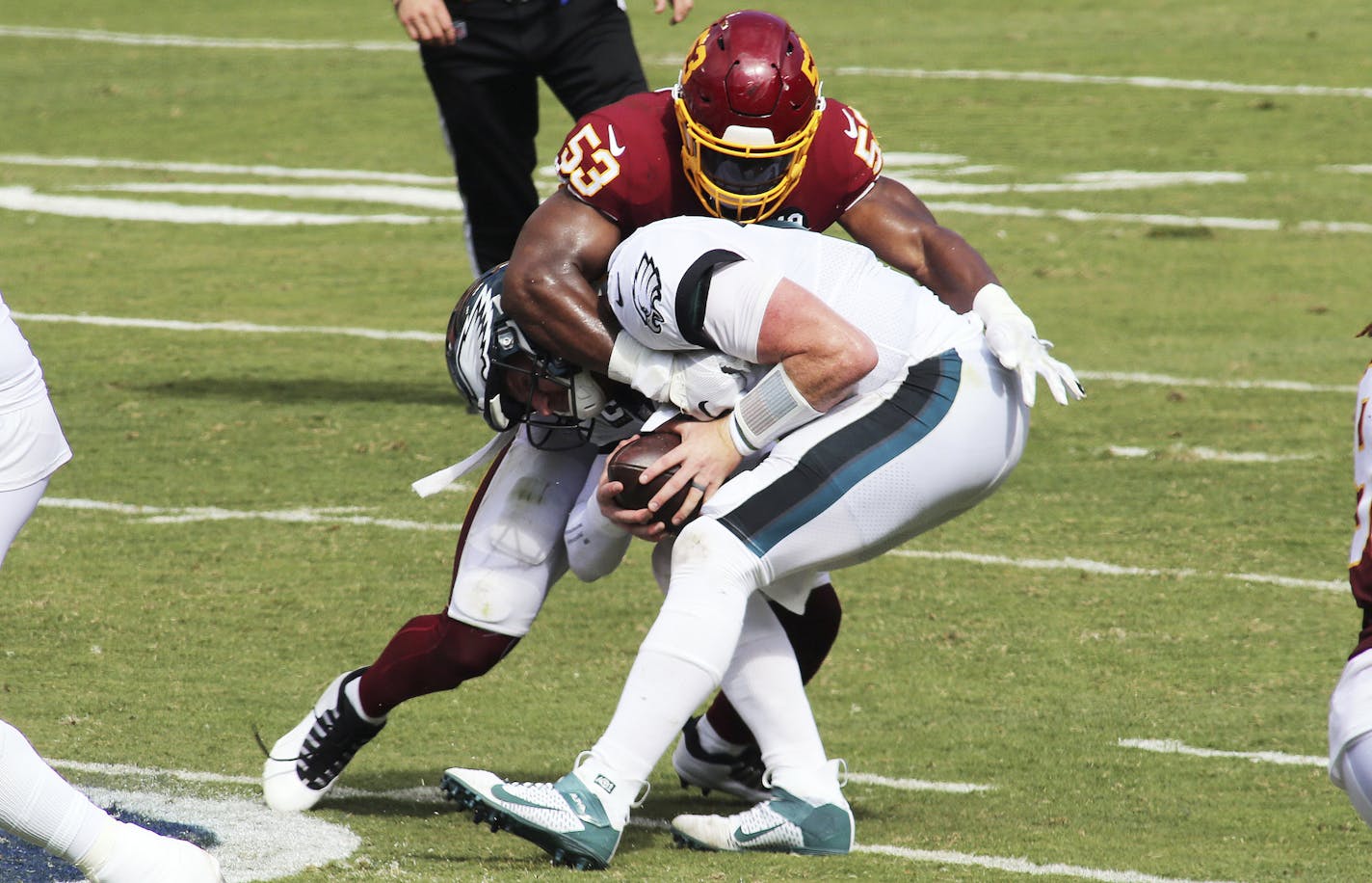 Washington Football Team linebacker Jon Bostic (53) takes down Philadelphia Eagles quarterback Carson Wentz (11) for a sack during a match against the Philadelphia Eagles in an NFL game, Sunday, September 13, 2020 in Landover, Md. (AP Photo/Daniel Kucin Jr.)