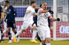 Minnesota United midfielder Osvaldo Alonso celebrates after a goal by Bakaye Dibassy during the first half of the team's MLS match against Sporting Ka
