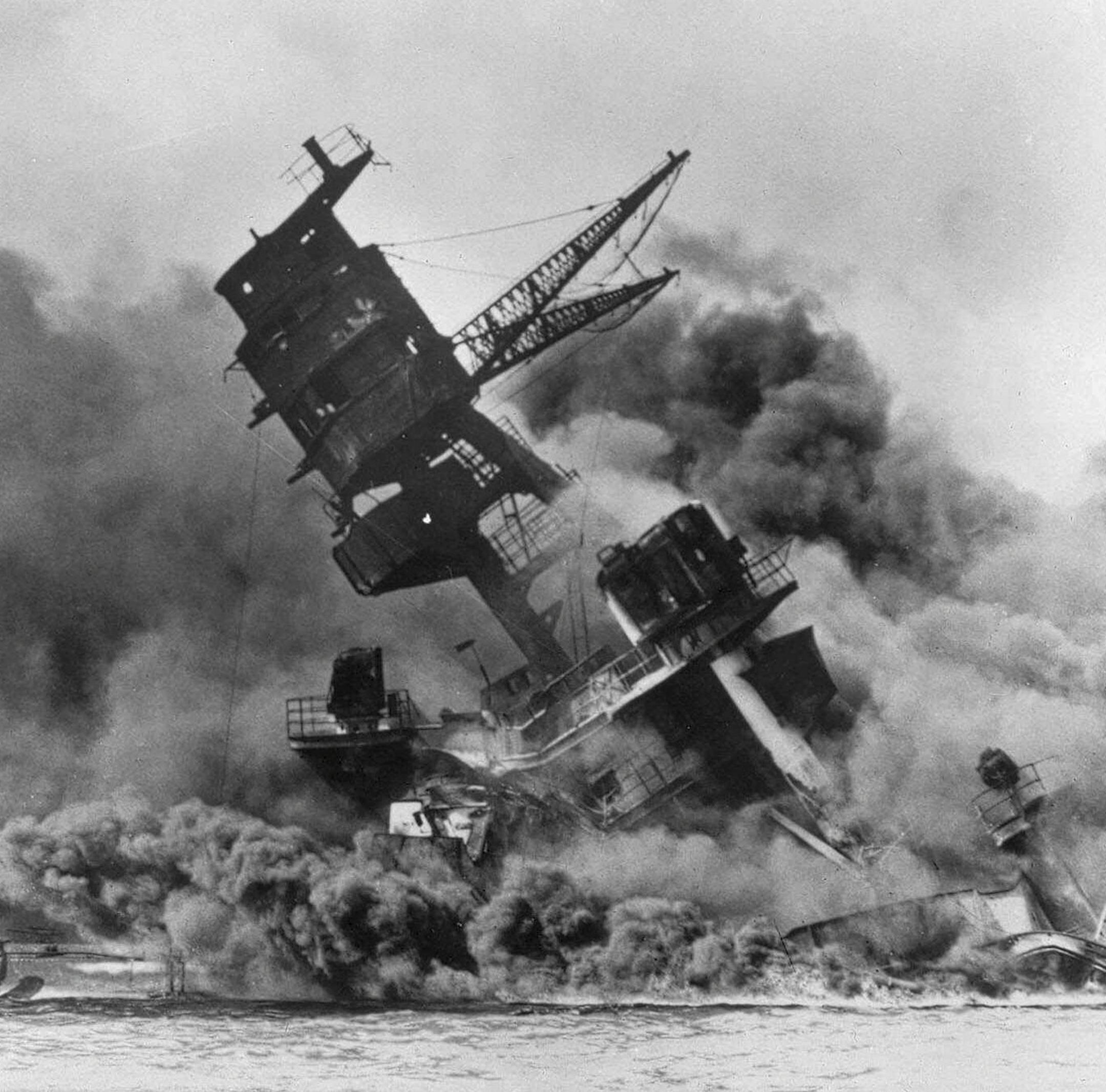 FILE - In this Dec. 7, 1941 file photo, smoke rises from the battleship USS Arizona as it sinks during the Japanese attack on Pearl Harbor, Hawaii. Divers will place the ashes of Lauren Bruner, a survivor from the USS Arizona in Pearl Harbor, in the wreckage of his ship during a ceremony this weekend. Bruner died earlier in 2019 at the age of 98. (AP Photo, File)