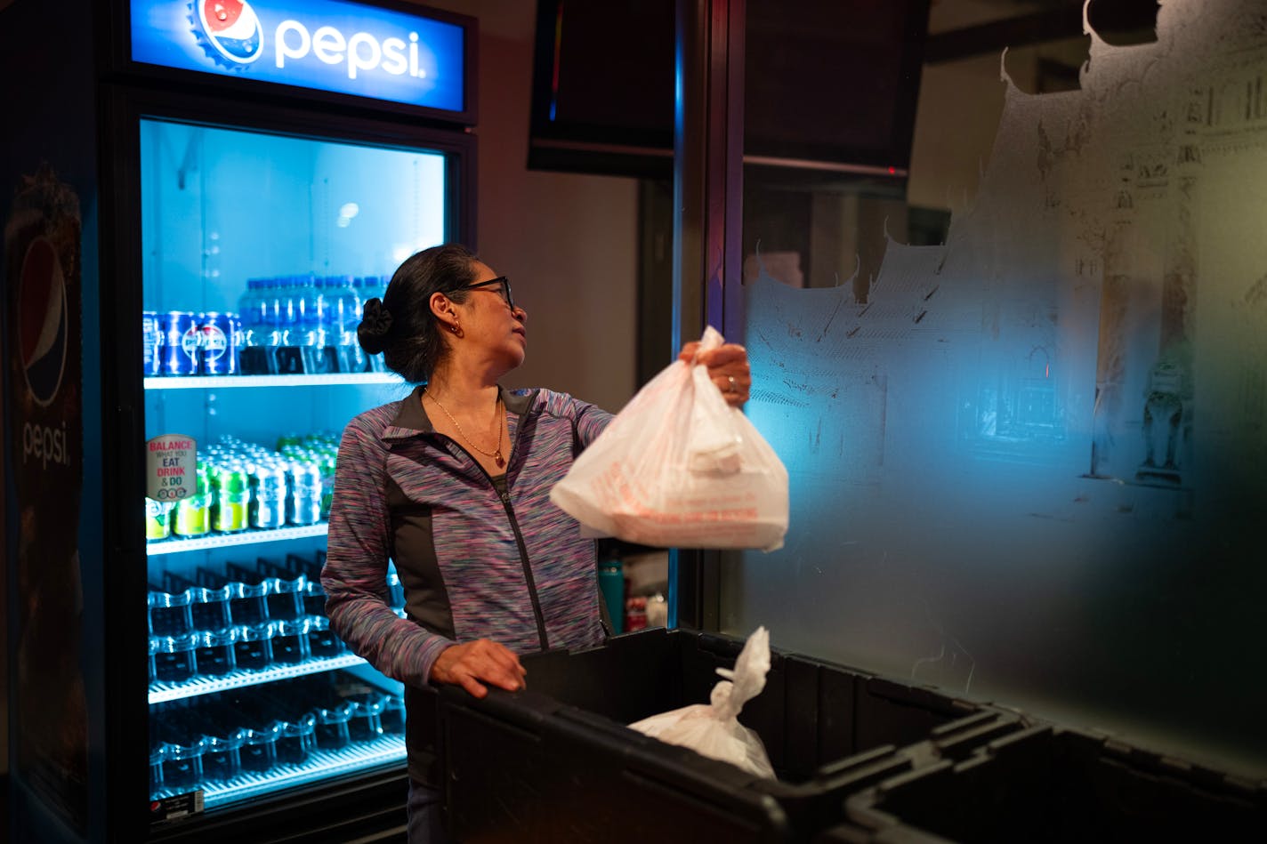 Sam Simonson looked for the correct takeout order for a waiting DoorDash delivery person at Sawatdee in Minneapolis Thursday night, December 14, 2023. Third party delivery food delivery services are a growing share of business at fast food restaurants and for other restaurants with cuisines that travel well like the Thai menu at Sawatdee in Minneapolis, where they account for 30% of their business. ] JEFF WHEELER • Jeff.Wheeler@startribune.com