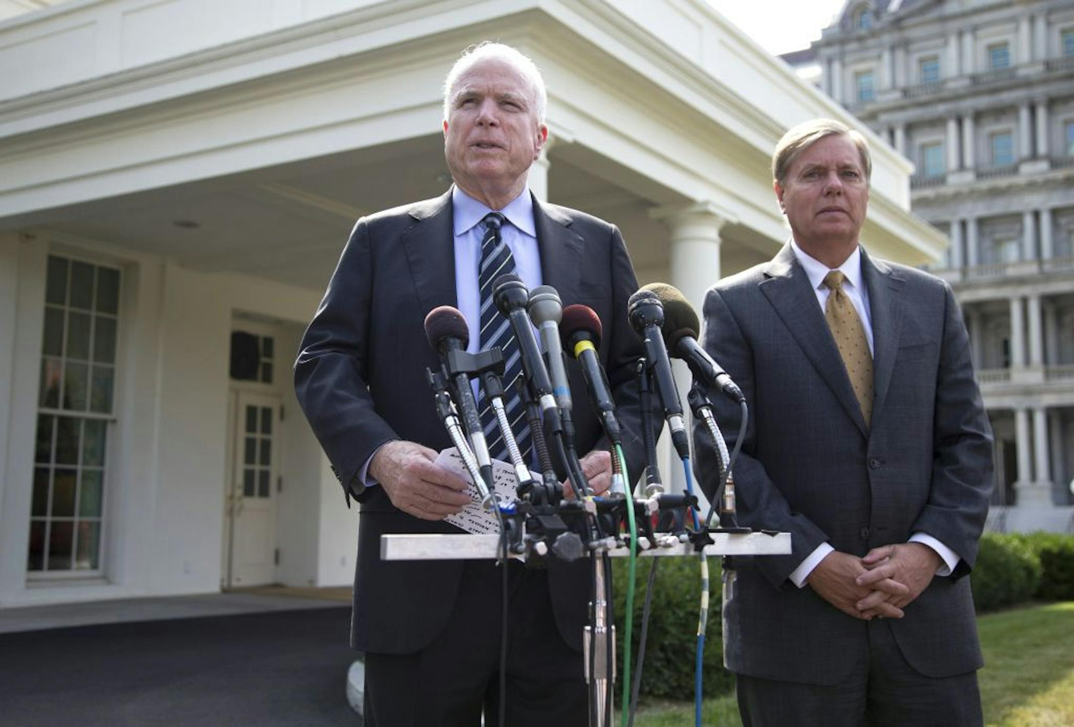 Sen. John McCain, R-Ariz., left, accompanied by Sen. Lindsey Graham, R-S.C., speaks with reporters outside the White House in Washington, Monday, Sept. 2, 2013, following a closed-door meeting with President Barack Obama to discuss the situation with Syria.