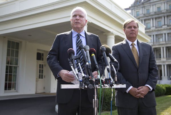 Sen. John McCain, R-Ariz., left, accompanied by Sen. Lindsey Graham, R-S.C., speaks with reporters outside the White House in Washington, Monday, Sept